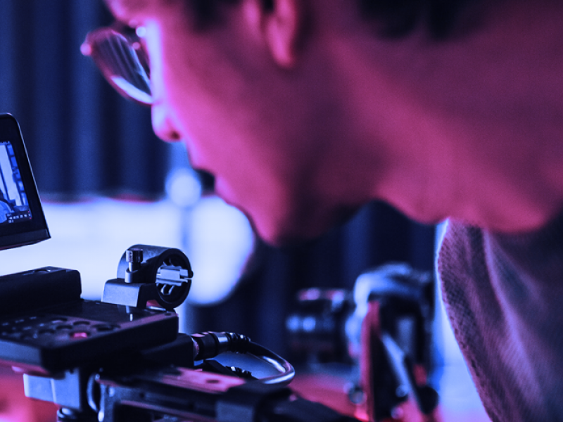 Student behind the camera filming.